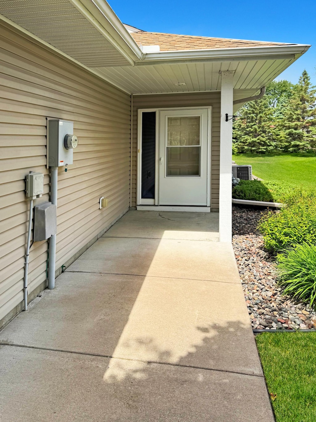 10783 Tyler Ct NE, Blaine, MN 55434 - doorway to property with a shingled roof and central AC