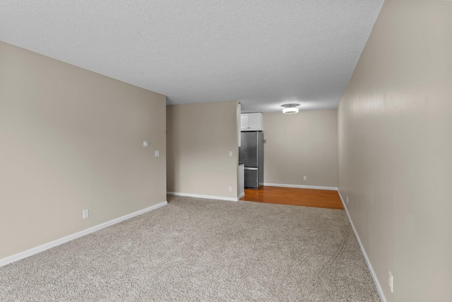 179 Little Canada Rd E Unit 230, Little Canada, MN 55117 - spare room featuring carpet, a textured ceiling, and baseboards
