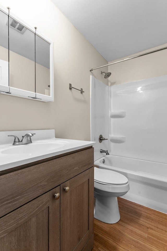 179 Little Canada Rd E Unit 230, Little Canada, MN 55117 - bathroom with vanity, toilet, bathing tub / shower combination, and wood finished floors