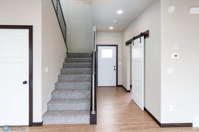405 16th St NE, Dilworth, MN 56529 - entrance foyer with light wood finished floors, stairway, baseboards, a barn door, and recessed lighting