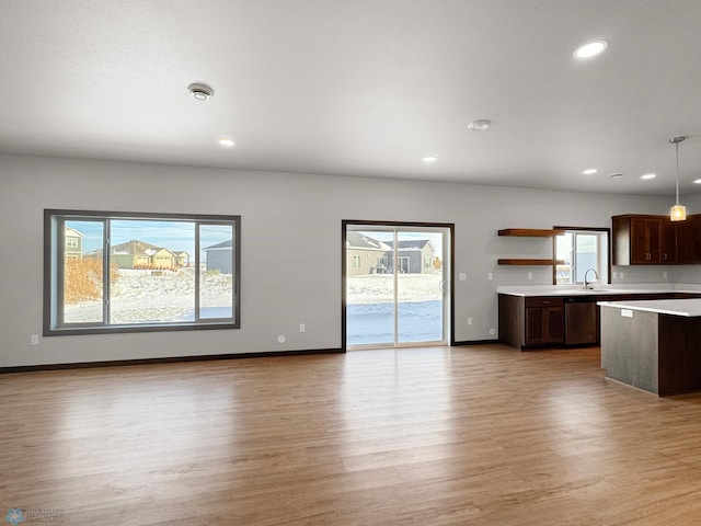 405 16th St NE, Dilworth, MN 56529 - kitchen with dishwasher, light countertops, light wood finished floors, open shelves, and pendant lighting