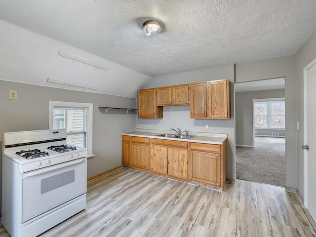818 Edmund Ave, Saint Paul, MN 55104 - kitchen with white gas range oven, a sink, light countertops, baseboards, and a textured ceiling
