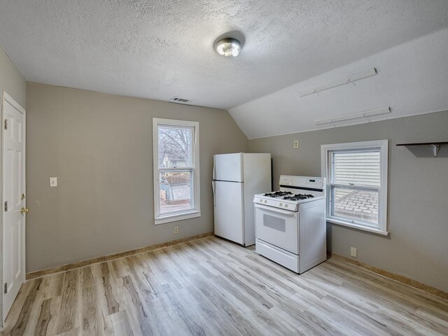 818 Edmund Ave, Saint Paul, MN 55104 - kitchen with white appliances, light wood-type flooring, a textured ceiling, lofted ceiling, and baseboards