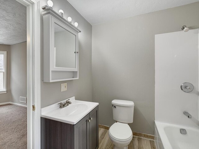818 Edmund Ave, Saint Paul, MN 55104 - full bath featuring a textured ceiling, vanity, toilet, baseboards, and shower / tub combination