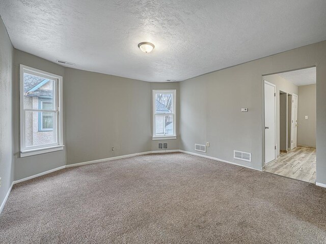 818 Edmund Ave, Saint Paul, MN 55104 - spare room with a textured ceiling, light carpet, and baseboards