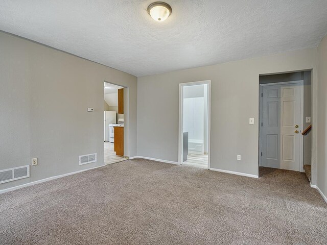 818 Edmund Ave, Saint Paul, MN 55104 - unfurnished bedroom featuring freestanding refrigerator, a textured ceiling, carpet flooring, baseboards, and ensuite bathroom