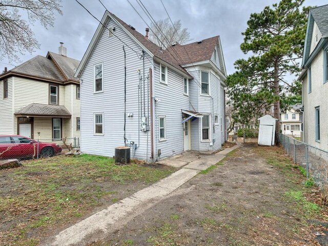 818 Edmund Ave, Saint Paul, MN 55104 - back of house with a chimney, central AC, and roof with shingles
