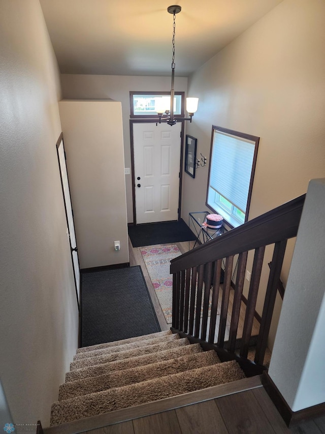 1743 46th Ave S, Moorhead, MN 56560 - stairway featuring a chandelier, wood finished floors, and baseboards