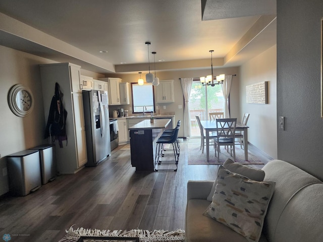 1743 46th Ave S, Moorhead, MN 56560 - kitchen with stainless steel fridge with ice dispenser, wood finished floors, white cabinetry, a kitchen breakfast bar, and a kitchen island