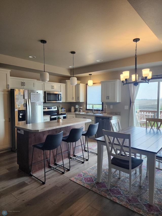 1743 46th Ave S, Moorhead, MN 56560 - kitchen with stainless steel appliances, a center island, dark wood-style flooring, a chandelier, and a sink
