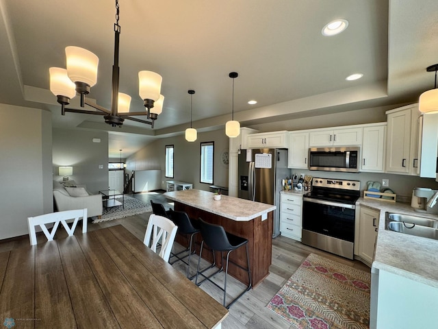 1743 46th Ave S, Moorhead, MN 56560 - kitchen featuring appliances with stainless steel finishes, a raised ceiling, a sink, light countertops, and recessed lighting
