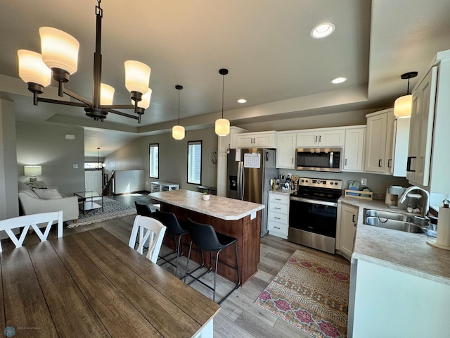 1743 46th Ave S, Moorhead, MN 56560 - kitchen with appliances with stainless steel finishes, a tray ceiling, a sink, light countertops, and recessed lighting