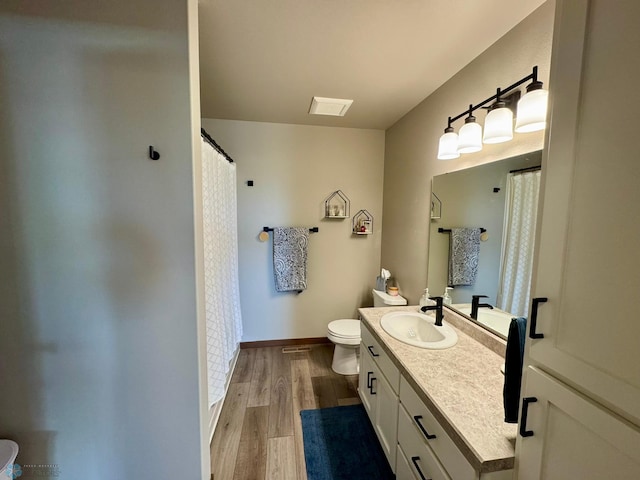 1743 46th Ave S, Moorhead, MN 56560 - full bathroom with vanity, toilet, a shower with shower curtain, and wood finished floors