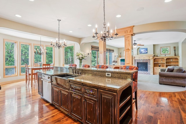 15758 Austin St NE, Ham Lake, MN 55304 - kitchen with a chandelier, a breakfast bar area, arched walkways, ceiling fan, and a brick fireplace