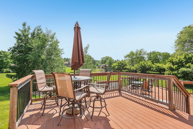 15758 Austin St NE, Ham Lake, MN 55304 - wooden deck featuring a playground, outdoor dining area, and view of wooded area