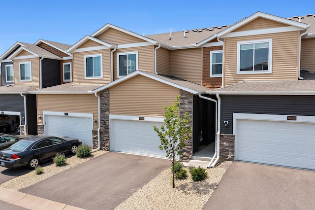 14834 Willemite Way NW, Ramsey, MN 55303 - townhome / multi-family property featuring stone siding, an attached garage, and driveway