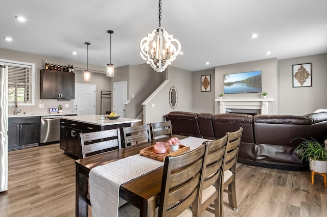 14834 Willemite Way NW, Ramsey, MN 55303 - dining room featuring recessed lighting, light wood-style flooring, a chandelier, and a fireplace