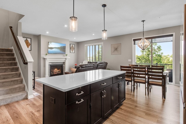 14834 Willemite Way NW, Ramsey, MN 55303 - kitchen with light wood-type flooring, light countertops, a premium fireplace, pendant lighting, and open floor plan
