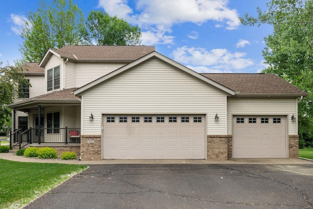 901 14th St N, Sartell, MN 56377 - view of front facade with brick siding, a porch, an attached garage, and driveway