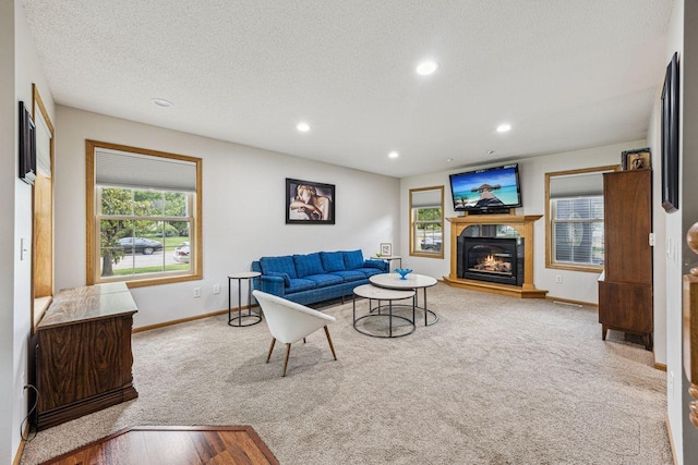 901 14th St N, Sartell, MN 56377 - carpeted living room with healthy amount of natural light, a glass covered fireplace, recessed lighting, and a textured ceiling