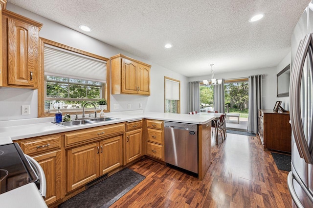 901 14th St N, Sartell, MN 56377 - kitchen with appliances with stainless steel finishes, a peninsula, a textured ceiling, plenty of natural light, and dark wood-type flooring