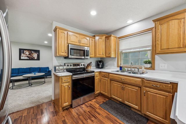 901 14th St N, Sartell, MN 56377 - kitchen featuring stainless steel appliances, dark wood-style flooring, light countertops, recessed lighting, and a textured ceiling