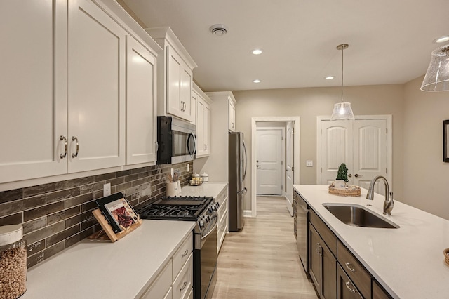 5054 Dale Ridge Rd, Woodbury, MN 55129 - kitchen with appliances with stainless steel finishes, a sink, white cabinetry, light countertops, and recessed lighting