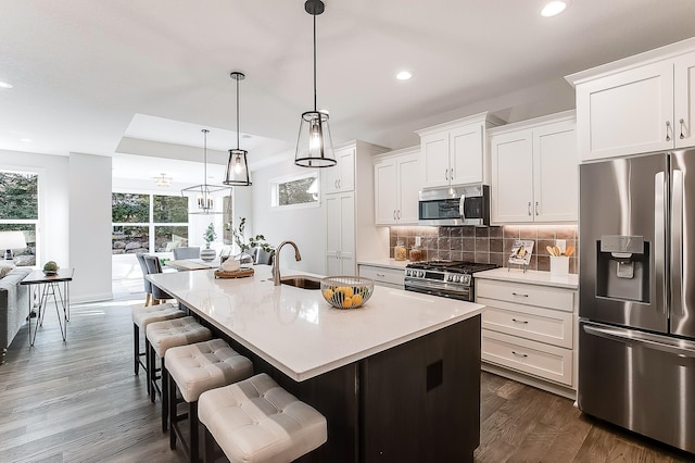 5054 Dale Ridge Rd, Woodbury, MN 55129 - kitchen with stainless steel appliances, decorative backsplash, recessed lighting, a kitchen island with sink, and a sink