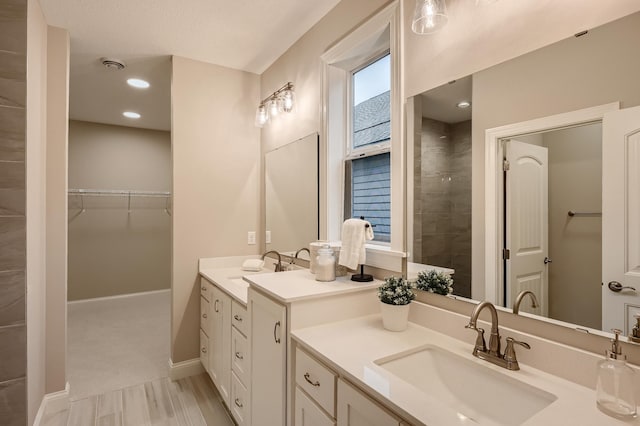 5054 Dale Ridge Rd, Woodbury, MN 55129 - bathroom featuring vanity, baseboards, a spacious closet, and wood finished floors