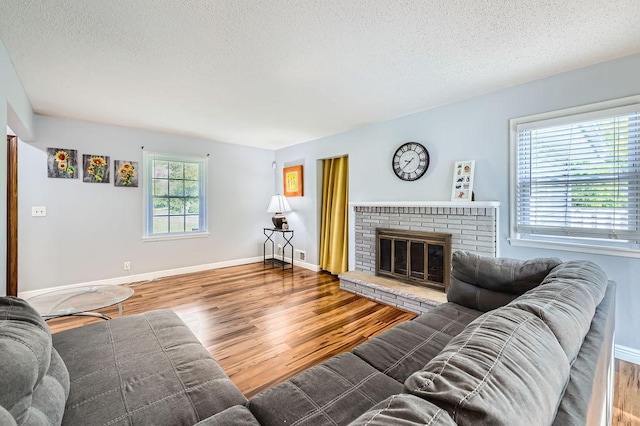 7724 Major Ave N, Brooklyn Park, MN 55443 - living area featuring wood finished floors, a textured ceiling, baseboards, and a fireplace