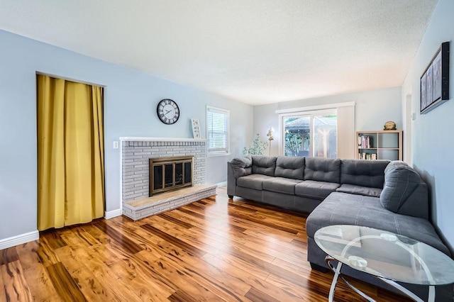 7724 Major Ave N, Brooklyn Park, MN 55443 - living room with wood finished floors, a brick fireplace, and baseboards