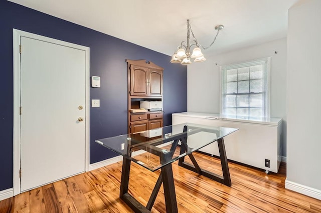 7724 Major Ave N, Brooklyn Park, MN 55443 - dining room with a chandelier, light wood-style floors, and baseboards