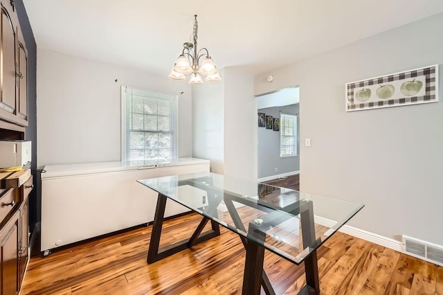 7724 Major Ave N, Brooklyn Park, MN 55443 - dining room featuring a chandelier, light wood-style floors, and baseboards