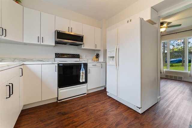 2508 Springvale Rd, Duluth, MN 55811 - kitchen with stainless steel microwave, range with electric cooktop, white refrigerator with ice dispenser, dark wood finished floors, and a ceiling fan