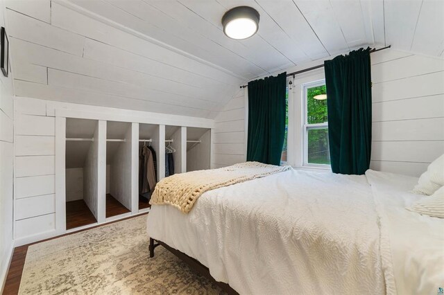 2508 Springvale Rd, Duluth, MN 55811 - bedroom with vaulted ceiling, wood finished floors, wooden walls, and a closet