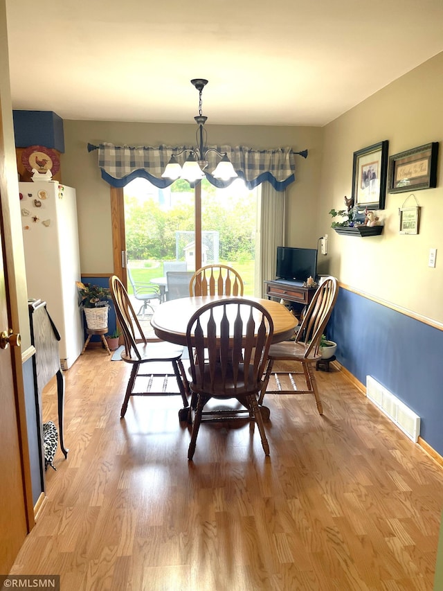 705 Turril St, Le Sueur, MN 56058 - dining room with wood finished floors, a chandelier, and baseboards