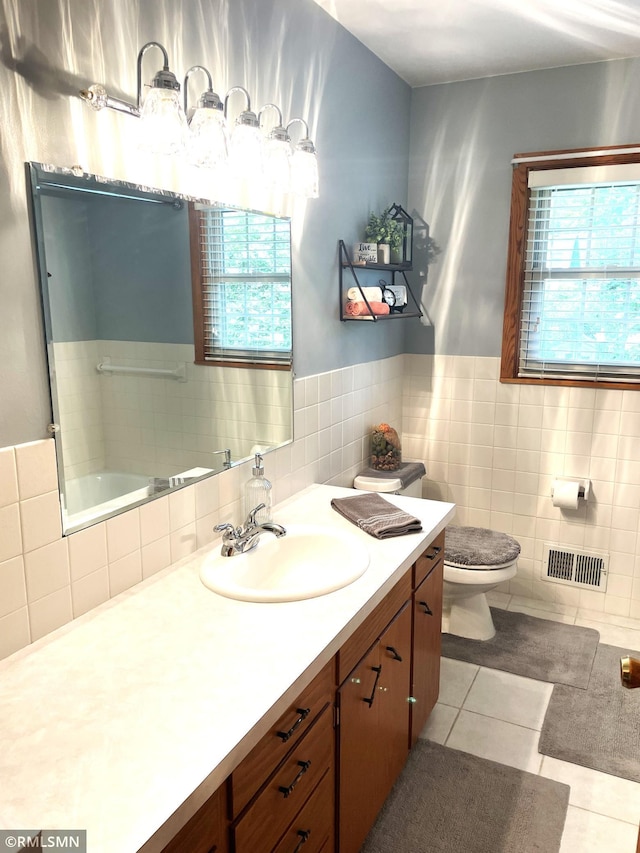 705 Turril St, Le Sueur, MN 56058 - full bathroom with tile patterned floors, tile walls, toilet, vanity, and wainscoting