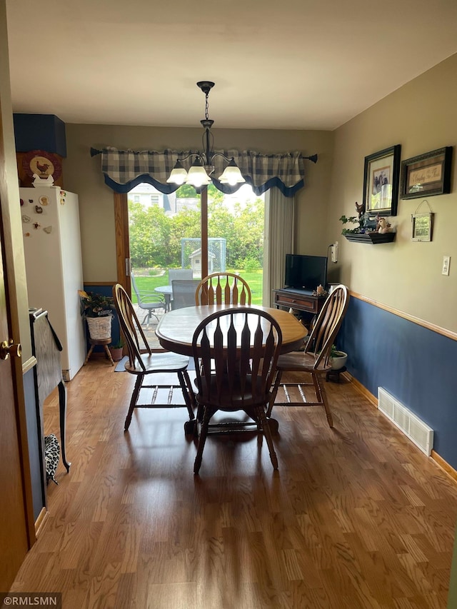705 Turril St, Le Sueur, MN 56058 - dining room with wood finished floors, a chandelier, and baseboards