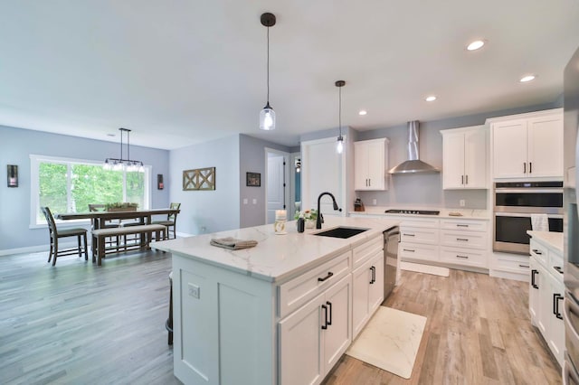 16460 Sanctuary Way, Brainerd, MN 56401 - kitchen with wall chimney range hood, a sink, stainless steel appliances, white cabinetry, and light wood finished floors