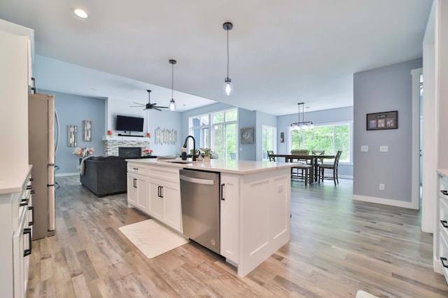 16460 Sanctuary Way, Brainerd, MN 56401 - kitchen with stainless steel appliances, a sink, open floor plan, a ceiling fan, and light wood finished floors
