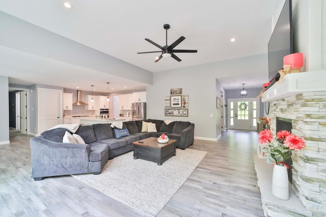 16460 Sanctuary Way, Brainerd, MN 56401 - living room featuring baseboards, light wood-style floors, a ceiling fan, a fireplace, and recessed lighting
