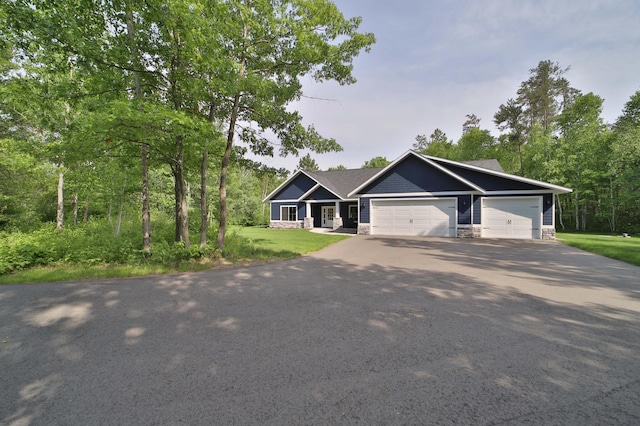 16460 Sanctuary Way, Brainerd, MN 56401 - view of front of property featuring asphalt driveway, an attached garage, stone siding, and a front lawn