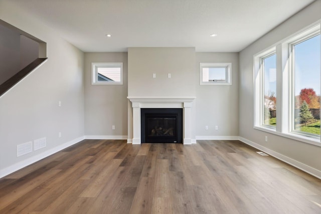 6135 Harkness Ln S, Cottage Grove, MN 55016 - unfurnished living room with a glass covered fireplace, wood finished floors, and recessed lighting
