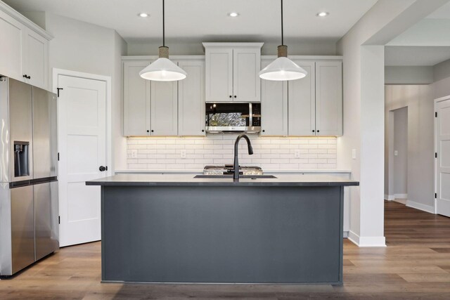 6135 Harkness Ln S, Cottage Grove, MN 55016 - kitchen featuring appliances with stainless steel finishes, recessed lighting, a center island with sink, tasteful backsplash, and pendant lighting