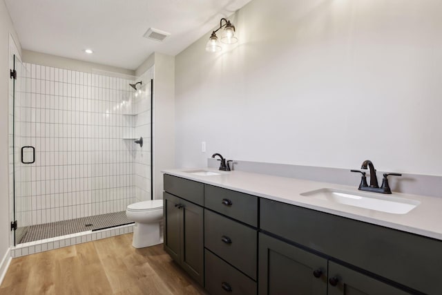 6135 Harkness Ln S, Cottage Grove, MN 55016 - bathroom featuring a shower stall, double vanity, wood finished floors, and recessed lighting