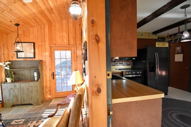 2645 Riverside Ln NE, Rochester, MN 55906 - kitchen with black fridge, wooden walls, stainless steel range with electric cooktop, and butcher block counters
