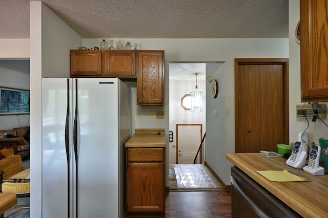 27681 Moser Dr, Jackson Twp, WI 54893 - kitchen featuring freestanding refrigerator, dark wood-type flooring, brown cabinets, light countertops, and a textured ceiling