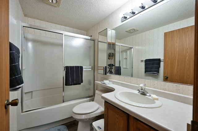 27681 Moser Dr, Jackson Twp, WI 54893 - full bath featuring wallpapered walls, vanity, toilet, a textured ceiling, and shower / bath combination with glass door