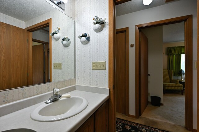 27681 Moser Dr, Jackson Twp, WI 54893 - bathroom featuring vanity, wallpapered walls, and a textured ceiling