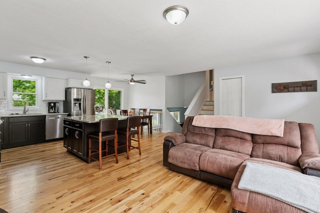 265 107th Ln NW, Coon Rapids, MN 55448 - living area featuring light wood-style flooring, ceiling fan, and stairway